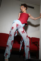 Abbie Chatfield wearing a red corset top and light blue pants with red bows