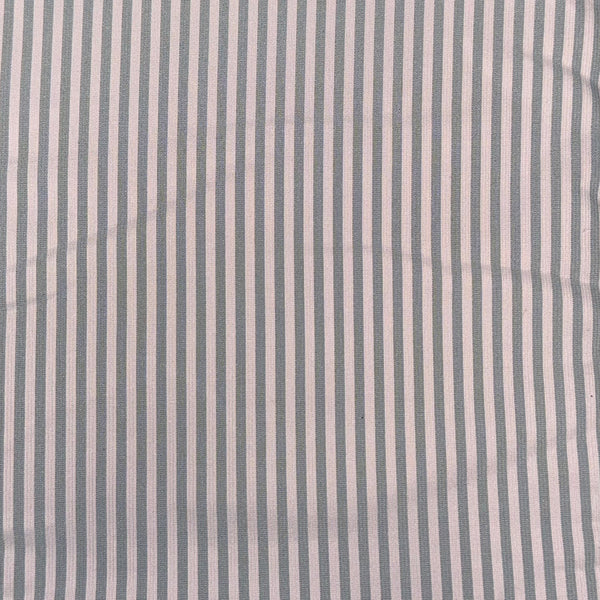 A close-up of a striped fabric with vertical light gray and pink stripes.